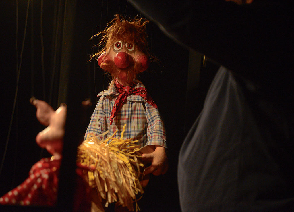 Peter Allen controls a marionette while performing "The Three Little Pigs"
